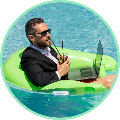 A man in a suit floating on a green pool float with a laptop and drink