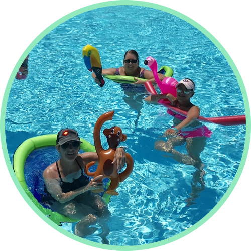 A group of people are in a swimming pool with inflatable toys.